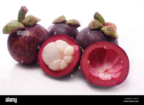 Mangosteen fruit and cross section showing the thick purple skin and white flesh of the queen of ...