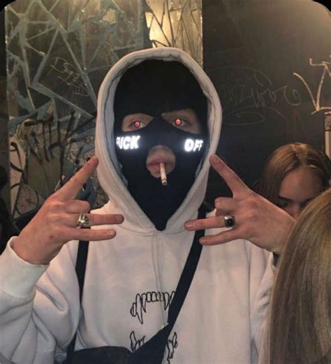 a person wearing a hoodie with lights on their face and fingers in ...