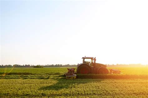 Premium Photo | Tractor makes harvesting hay for animals on a farm