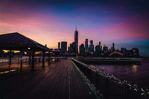 Brown Wooden Dock Near City Buildings during Sunset · Free Stock Photo