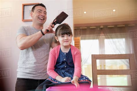 Father brushing daughter's hair - Stock Photo - Dissolve