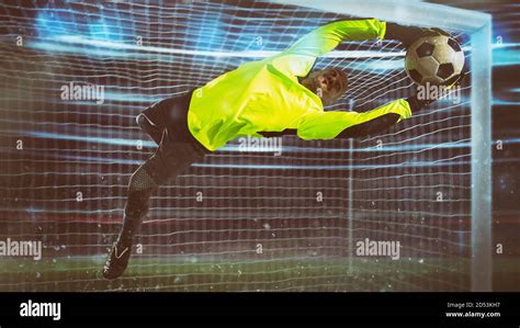 Soccer goalkeeper, in fluorescent uniform, makes a save and avoids a ...