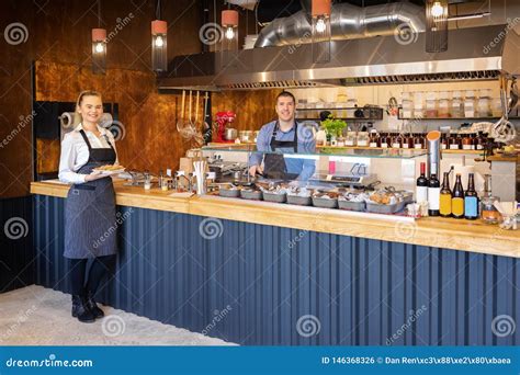 Counter Service at Modern Bistro with Smiling Waiters Serving Food â ...