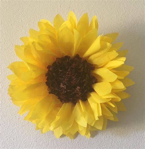 a large yellow flower is hanging on the wall