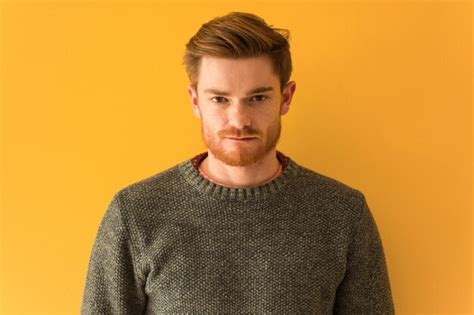 Premium Photo | Young redhead man onn orange wall