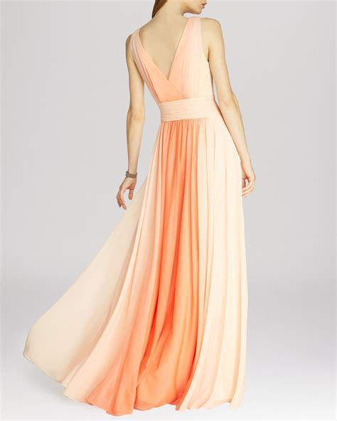 a woman in an orange and pink dress is standing with her back to the camera