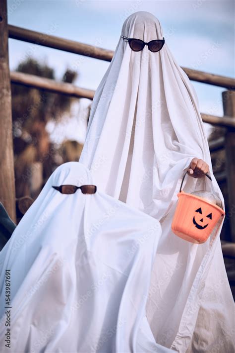 Halloween, friends and ghost costume for fun, festival and celebration while bonding at park ...