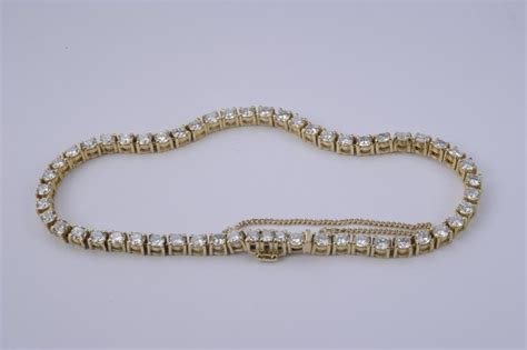 An 18k gold and diamond tennis bracelet. - Lot 224