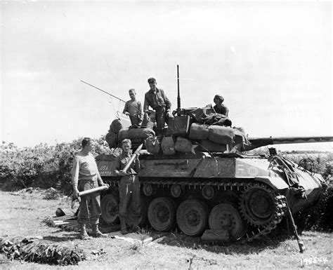 The crew of an M18 Tank Destroyer from B Company, 603rd Tank Destroyer Battalion, loading up on ...