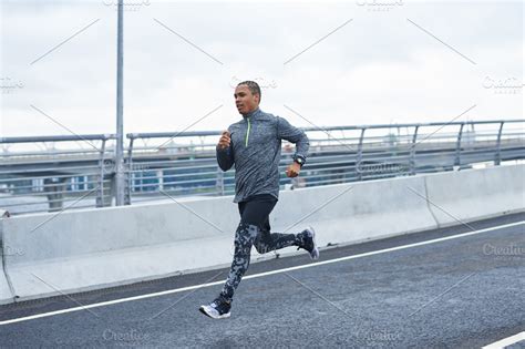 Black male runner exercising outdoors. Handsome fashionable young Afro ...