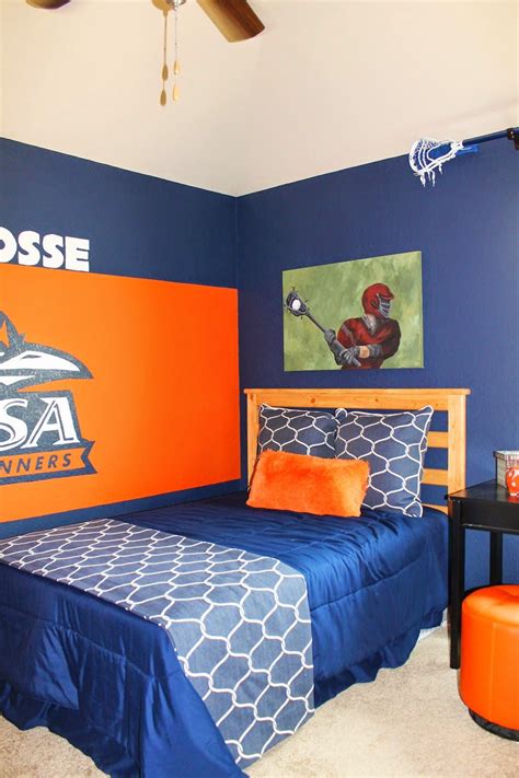 Boys lacrosse themed bedroom. Lacrosse sticks hanging on walls, team logo painted on wall, and ...