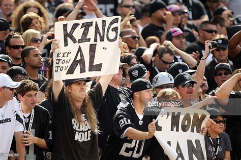 Fans hold up signs in honor of Oakland Raiders owner Al Davis before ...