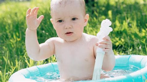 Little Baby Boy Swimming in an Inflatable Pool and Playing in the Summer on a Green Meadow Stock ...