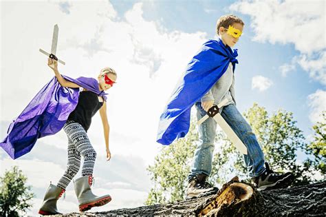 Caucasian children in costumes playing with swords stock photo