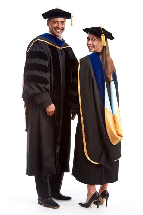 two people in graduation gowns posing for a photo