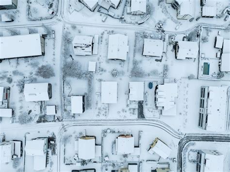 Premium Photo | Aerial view of town with snow covered houses. roof tops with snow on residential ...