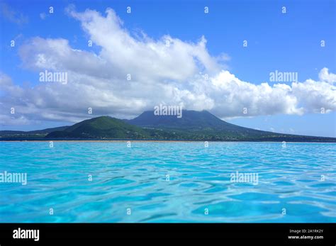 Day view of the Nevis Peak volcano across the water from St Kitts Stock Photo - Alamy