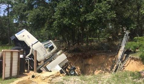 A sinkhole triggered during well drilling damages rig. (photograph ...