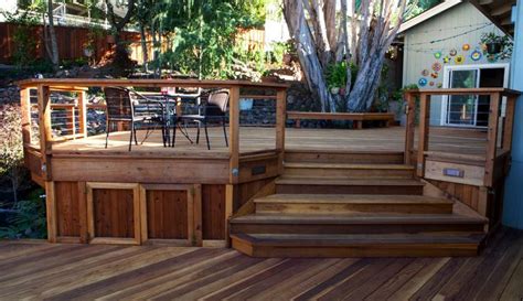 a wooden deck with steps leading up to a table and chairs