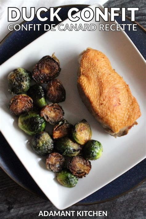 a white plate topped with chicken, brussel sprouts and a piece of bread