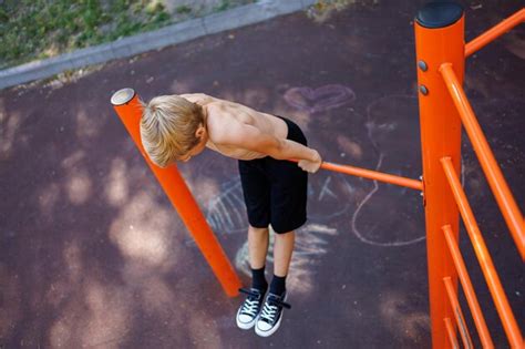 Premium Photo | Sports teenager on the horizontal bar performs ...