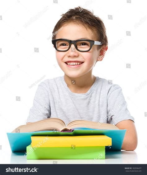 Cute Little Boy Is Reading A Book While Wearing Glasses, Isolated Over White Stock Photo ...