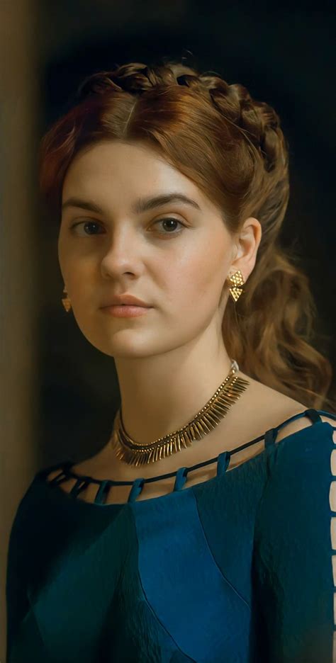 a woman in a blue dress with gold jewelry on her neck and shoulder ...