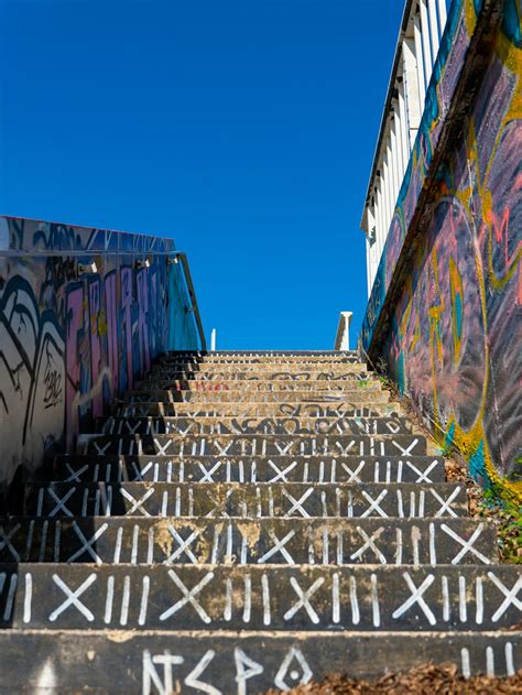 A set of stairs covered in graffiti next to a building photo – Free Street photography Image on ...