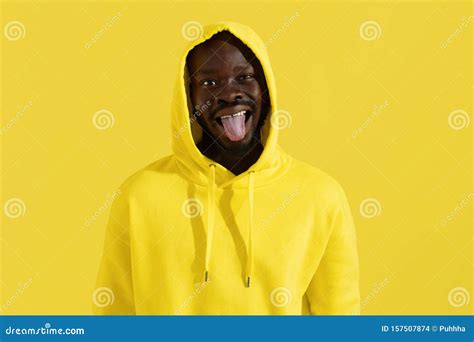 Black Man in Yellow Hoodie Making Funny Face on Color Background Stock ...