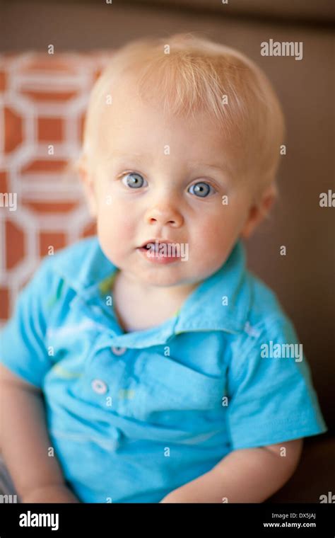 Wide-eyed baby boy with blonde hair and blue eyes, portrait, close up ...