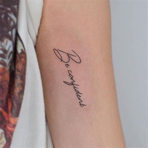 "Be confident" lettering tattoo on the bicep