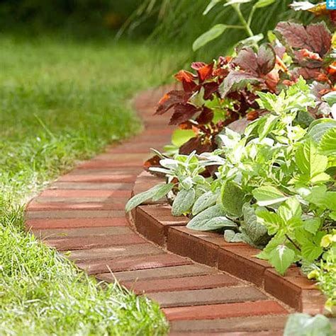 a brick garden border with green and red plants