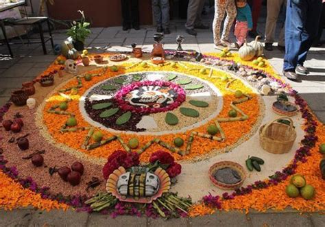 people standing around a large flower arrangement on the ground with ...