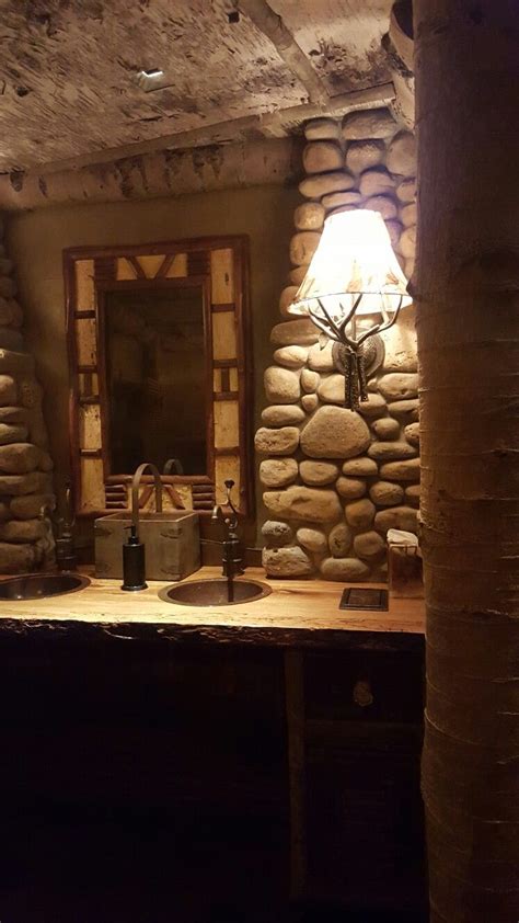 a rustic bathroom with stone walls and flooring