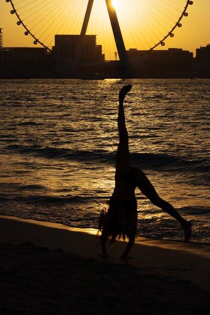 Premium Photo | Silhouette of woman doing cartwheel at sunset