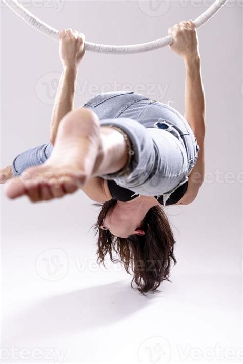 A female Aerial hoop gymnast performing exercises on an Aerial hoop ...