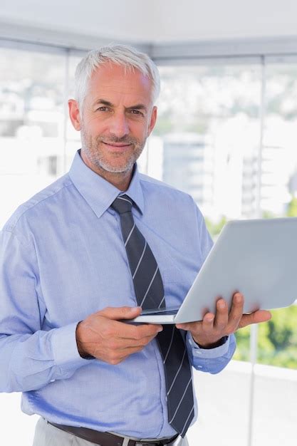 Premium Photo | Happy businessman holding laptop