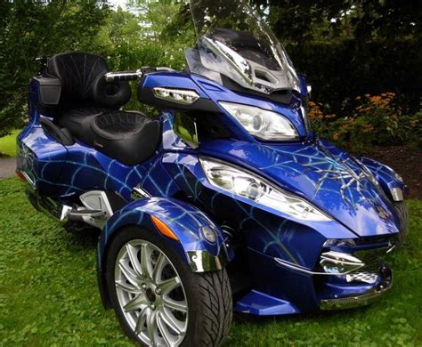 a blue motorcycle parked on top of a lush green field