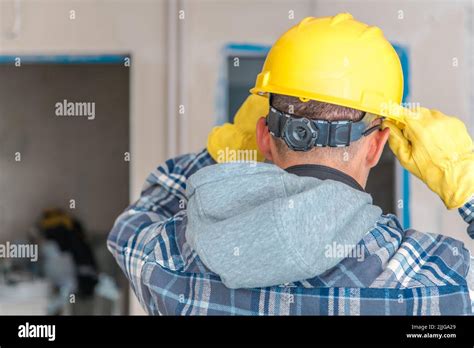 Caucasian Contractor Worker Putting On His Adjustable Yellow Safety ...