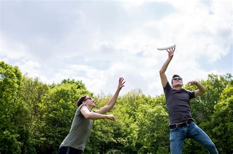 Free Photo | Young guys playing frisbee in nature