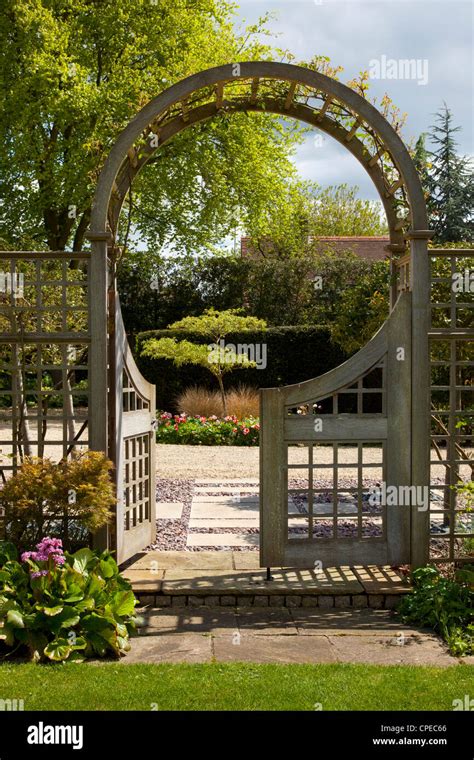 Garden feature Arch with gates leading into stone and pebble area Stock Photo, Royalty Free ...