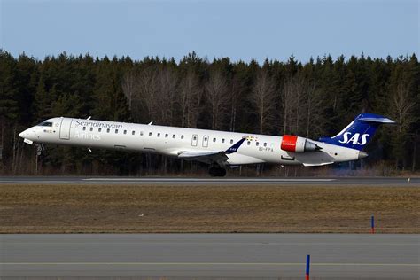 a large passenger jet taking off from an airport tarmac with trees in the background