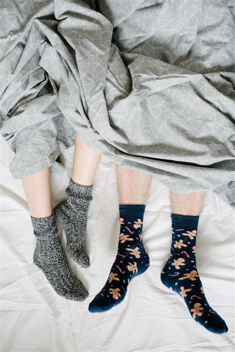 Premium Photo | Feet in socks under a blanket in bed