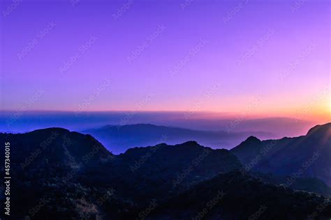 A stunning sunset or sunrise scene of silhouette mountain peaks and ...