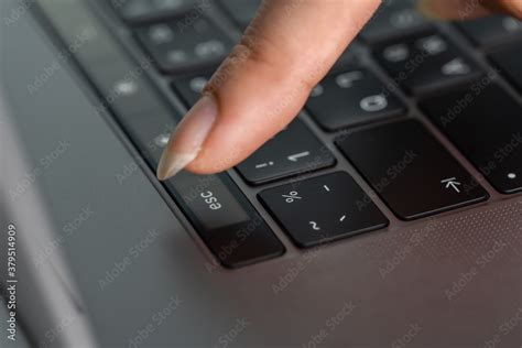 close-up female hand pressing esc button on laptop keyboard Stock Photo ...