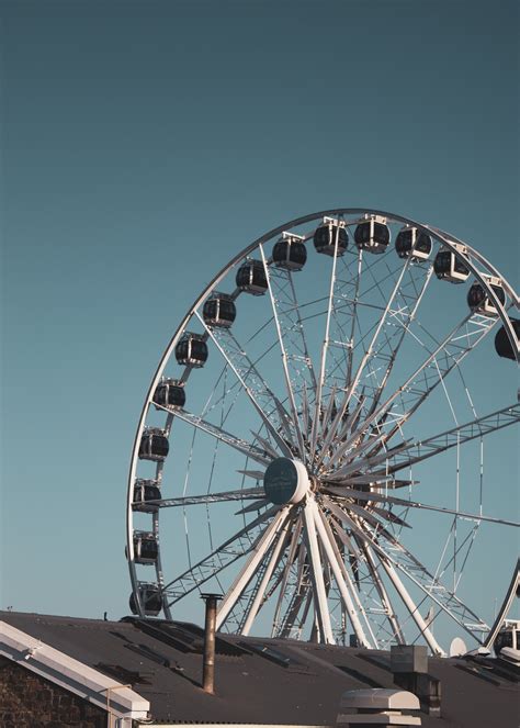 Ferris wheel above building in city park · Free Stock Photo