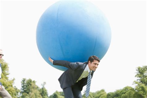 Businessman Holding Large Ball On Back Stock Photo - Download Image Now - iStock