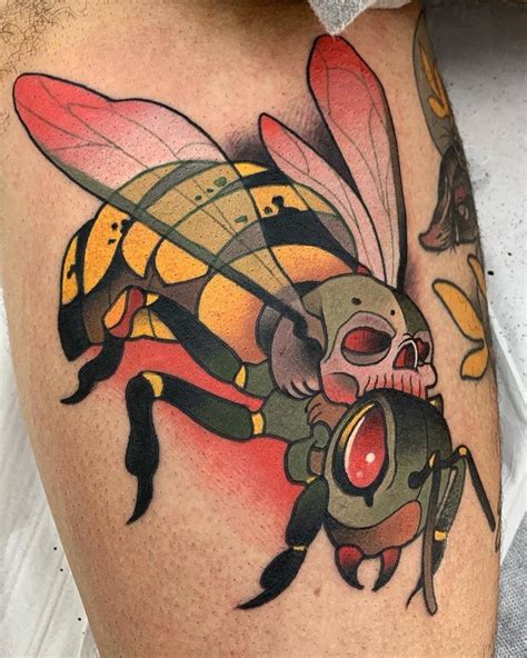 a man with a bee tattoo on his thigh and chest is holding a red object