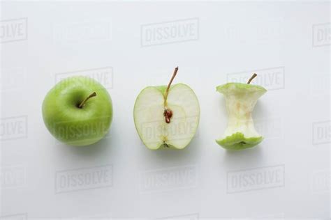 A whole apple, half an apple and an apple core - Stock Photo - Dissolve