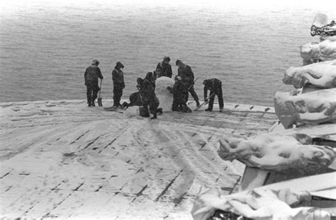 Crew members of the amphibious assault ship USS GUADALCANAL (LPH-7) take a break to build a snow ...